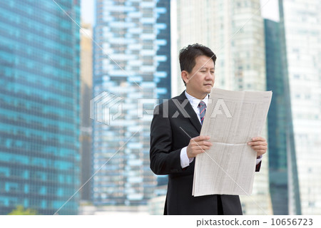 Successful entrepreneur stock agent business man reading newspaper in front of glass office building 10656723