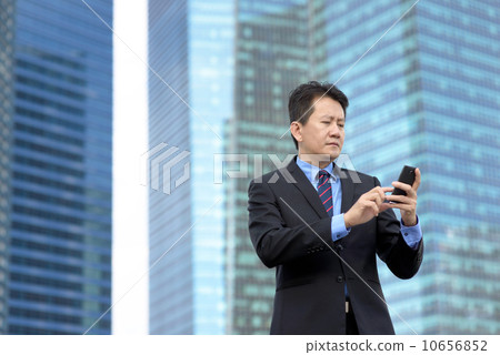 Successful entrepreneur business man using mobile phone in front of glass office building 10656852