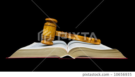 Gavel lies on the open book. black background. 10656935