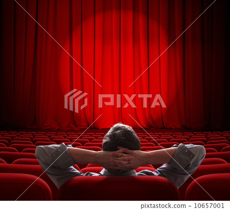 man sitting alone in  empty theater or cinema hall 10657001