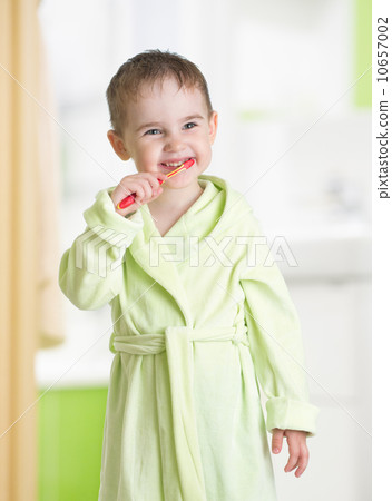 kid brushing teeth in bathroom 10657002