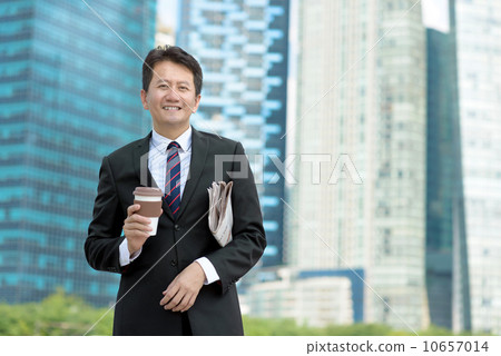 Successful entrepreneur business man holding coffee cup and newspaper in front of office building Successful entrepreneur business man holding coffee cup and newspaper in front of office building 10657014