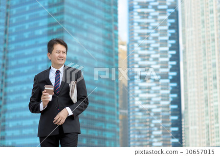Successful entrepreneur business man holding coffee cup and newspaper in front of office building Successful entrepreneur business man holding coffee cup and newspaper in front of office building 10657015