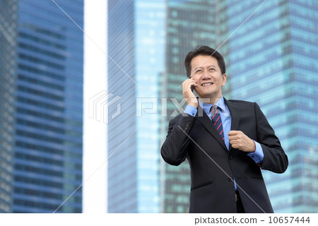 Successful entrepreneur business man using mobile phone in front of glass office building 10657444