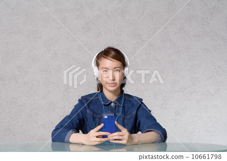 A woman listening to music on a smartphone A woman listening to music on a smartphone 10661798