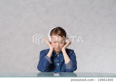 A woman listening to music on a smartphone A woman listening to music on a smartphone 10661800