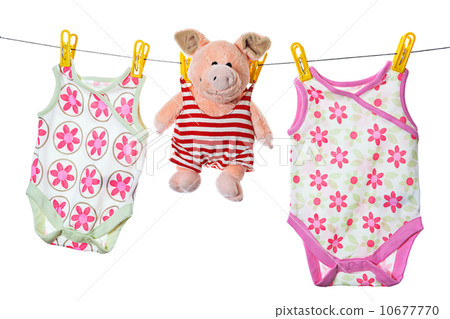 Baby sleepers and pig on the clothesline, studio isolated on whi 10677770