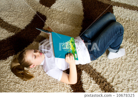 girl reading a book on the carpet 10678325