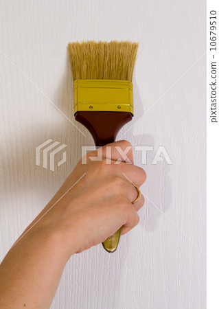 The hand paints with a brush a wall 10679510