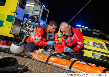 Paramedics giving firstaid to motorbike driver Paramedics giving firstaid to motorbike driver 10680201