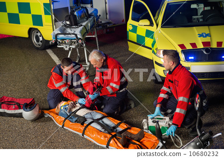 Paramedics helping motorbike driver on stretcher 10680232