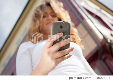 Woman using cellphone on the street Woman using cellphone on the street 10689097