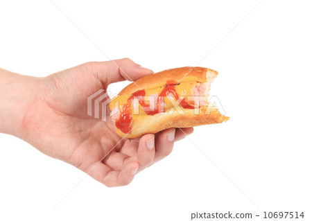 Hand holds bitten hotdog. 10697514
