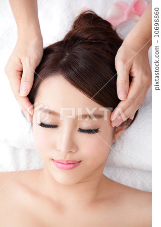 woman enjoy receiving face massage at spa with roses 10698860