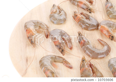 Raw shrimps on wooden round board. 10703606