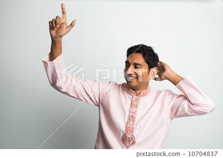 young indian male in traditional cloths dacing with bhangra musi young indian male in traditional cloths dacing with bhangra musi 10704837