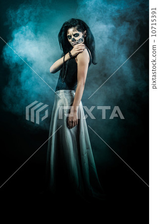 Young woman in day of the dead mask skull. Halloween face art Young woman in day of the dead mask skull. Halloween face art 10715391