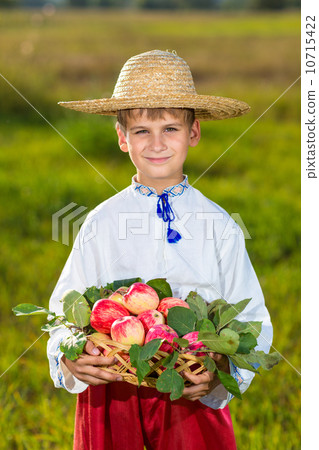 Happy farmer boy hold Organic Apples in Autumn Garden 10715422