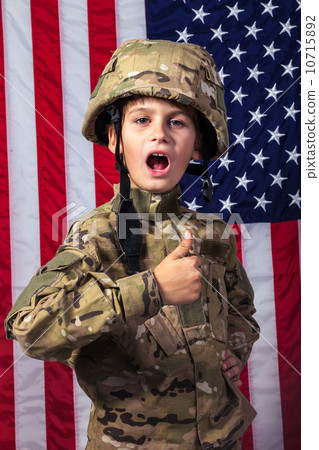 Young boy dressed like a soldier with American flag Young boy dressed like a soldier with American flag 10715892