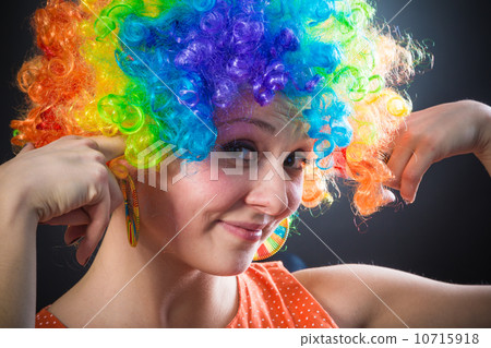 Woman in clown's wig smiling pulling fake hair on the sides Woman in clown's wig smiling pulling fake hair on the sides 10715918
