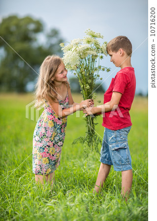 Spring. Boy gives  girl a bouquet of flowers . 10716200
