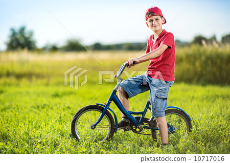 Young boy riding bicycle in a park Young boy riding bicycle in a park 10717016