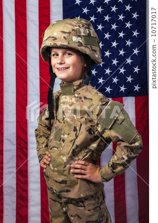 Young boy dressed like a soldier with American flag Young boy dressed like a soldier with American flag 10717017