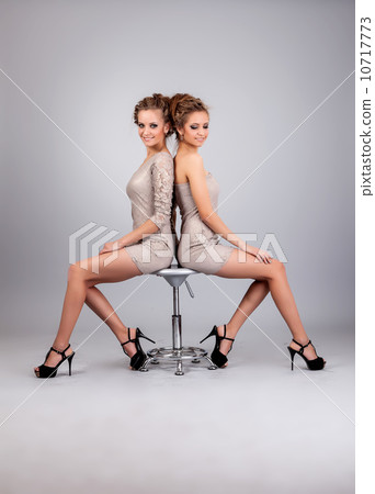 Two girls twins, isolated on the grey background Two girls twins, isolated on the grey background 10717773