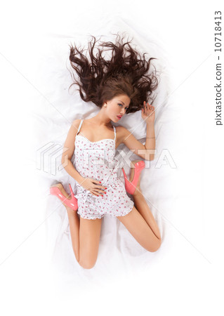 Portrait of beautiful young woman lying in bed 10718413