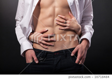 Woman's hands on a sexy man's torso 10718484