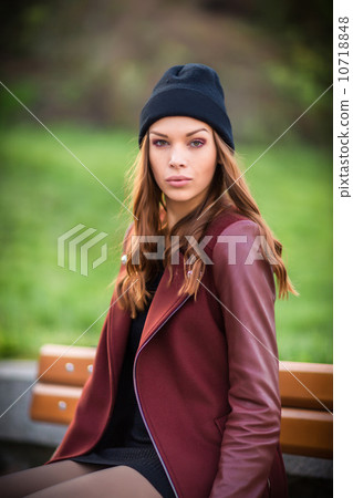 Young woman sitting on a bench. 10718848