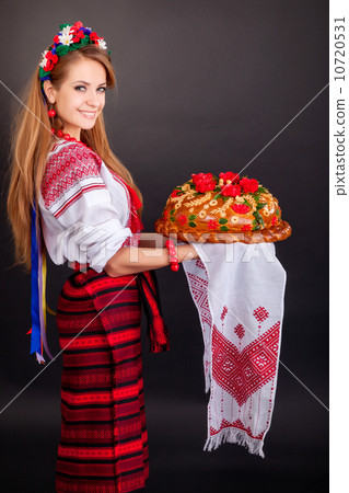 Young woman in ukrainian clothes, with garland and round loaf Young woman in ukrainian clothes, with garland and round loaf 10720531
