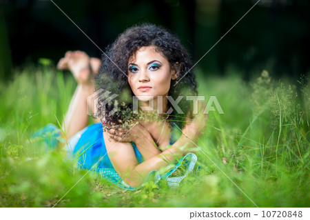 Young relaxing female lying on her stomach in the grass Young relaxing female lying on her stomach in the grass 10720848