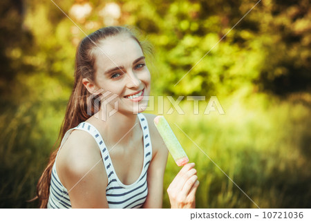 young woman eating colorful ice cream outdoors 10721036