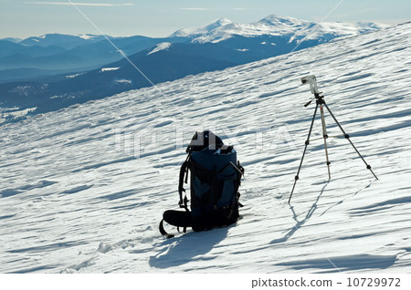 knapsack and tripod in winter mountains 10729972