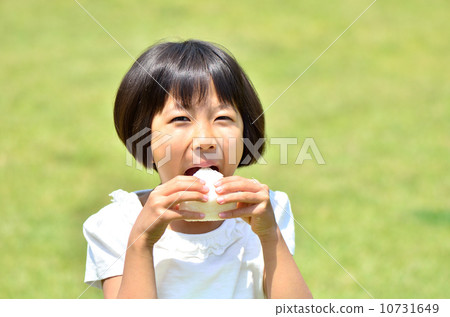 A girl who eats onigiri at the lawn plaza 10731649