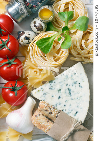 Overhead view of ingredients for an Italian pasta recipe on rust 10747395
