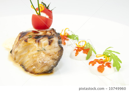 Roasted fillet of grilled fish in a white sauce 10749960
