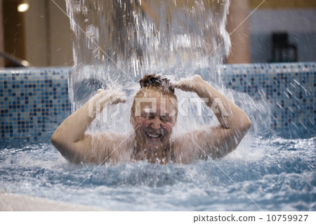 Woman playing under a water fountain Woman playing under a water fountain 10759927