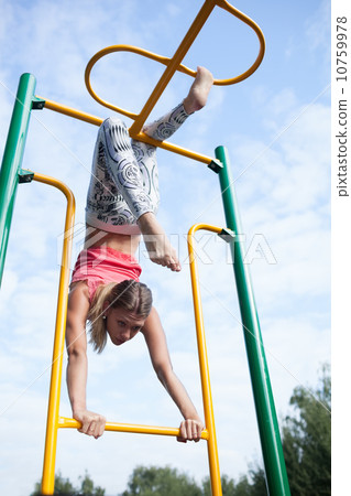 Beautiful young gymnast working out outdoors 10759978