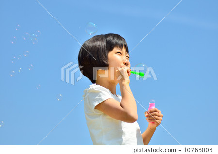 Girl playing soap bubble (blue sky) 10763003