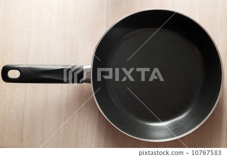 Black pan closeup photo on wooden background Black pan closeup photo on wooden background 10767583