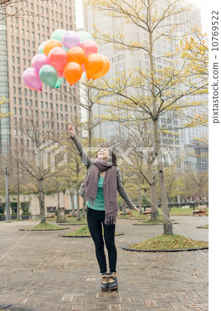 Happy smiling Asian woman holding balloons Happy smiling Asian woman holding balloons 10769522
