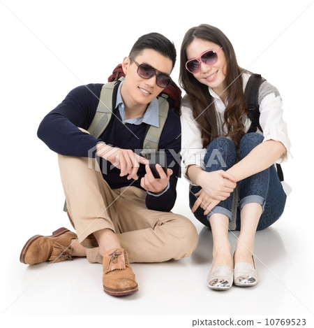 Happy traveling Asian couple sitting on ground and using cellpho Happy traveling Asian couple sitting on ground and using cellpho 10769523