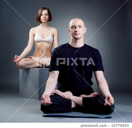 Shot of meditating yoga trainers, on gray backdrop 10778403