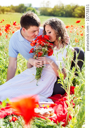 Young happy couple on a meadow full of poppies 10778831