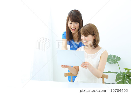 A young lady who uses a laptop computer, two people 10784403