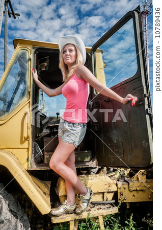 Young attractive woman on old big tractor 10789436