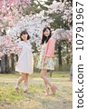 Two young women enjoying spring under the cherry tree 10791967