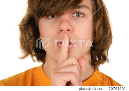 Teenager holds finger before lips Teenager holds finger before lips 10795601